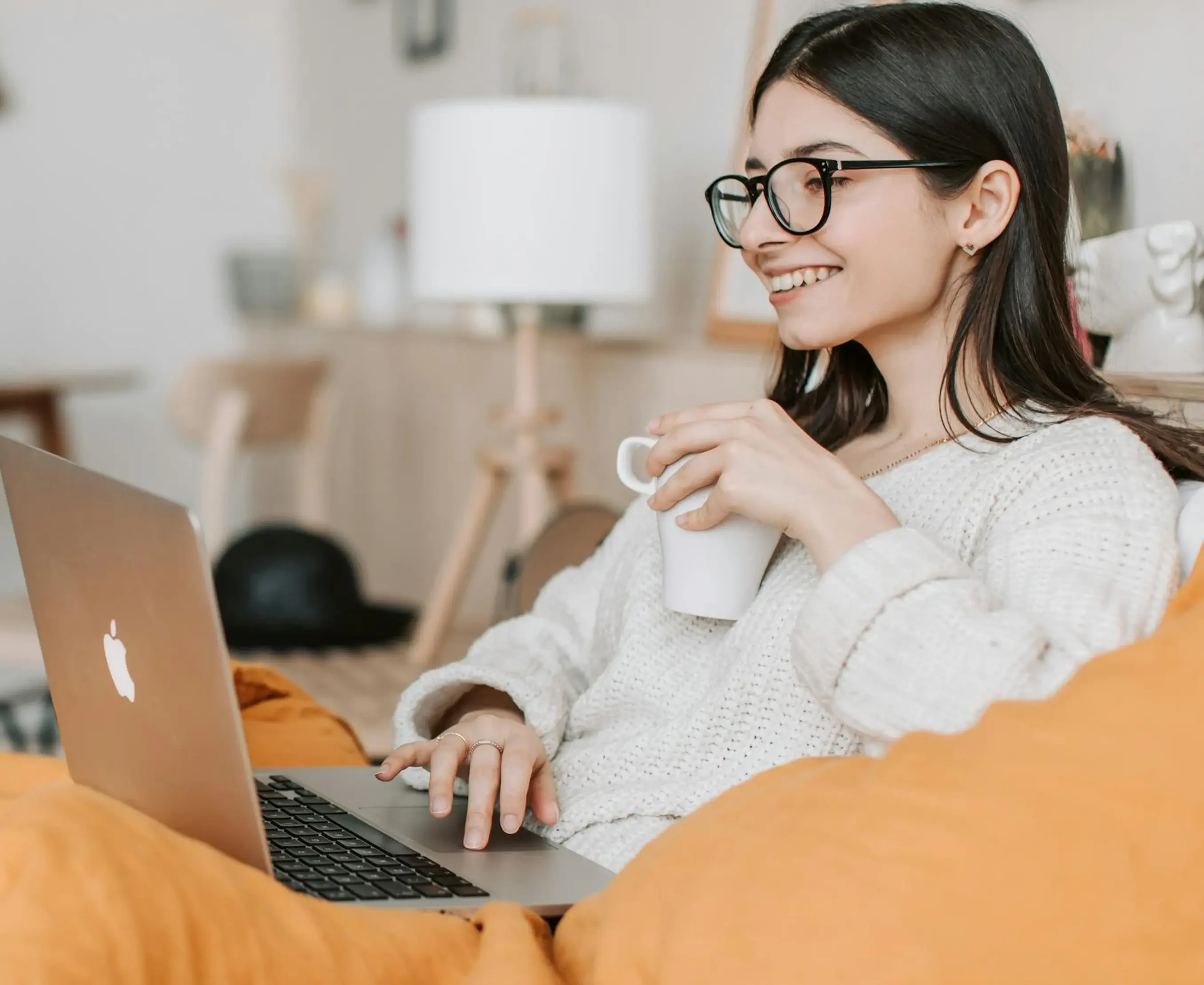 Una mujeer trabando en lu laptop desde el sofa