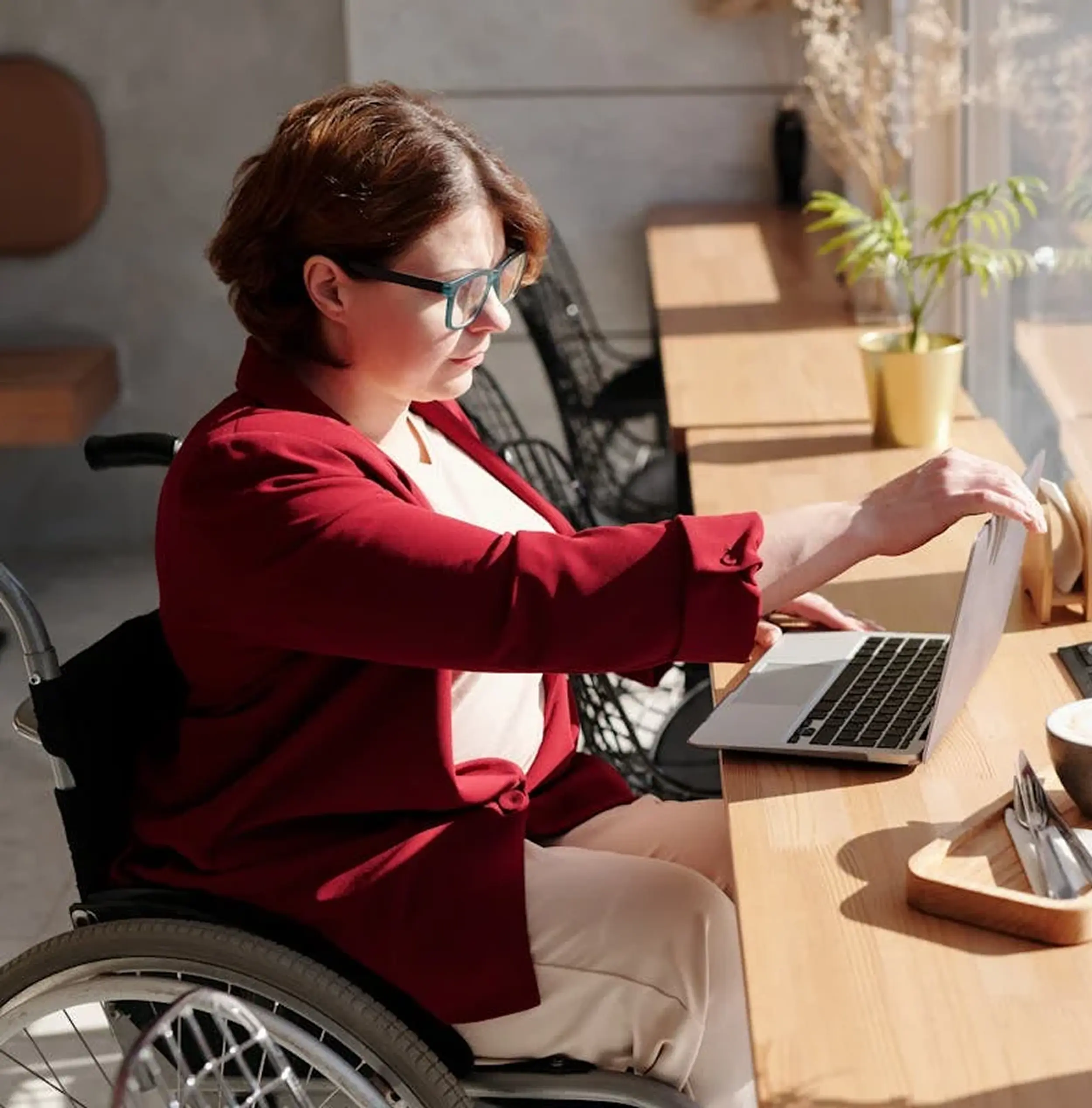 Persona PMR in una caffetteria e che guarda il suo laptop
